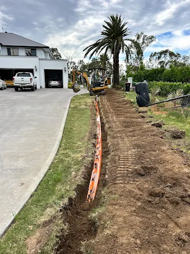 Electrical conduit laid in a trench along a driveway